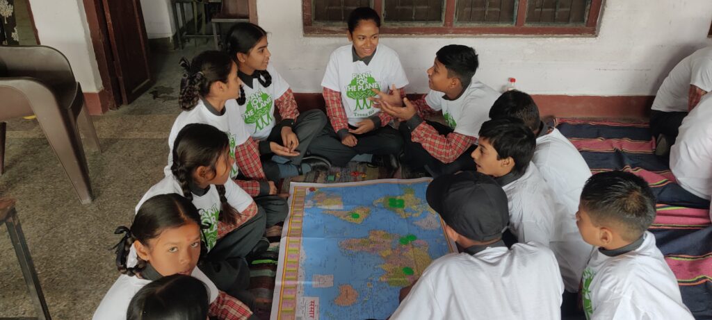 Children in Plant-for-the-Planet T shirts discussing the project